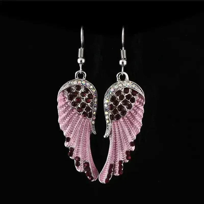 Angel wings fashion earrings with rhinestones dangling against a black background.