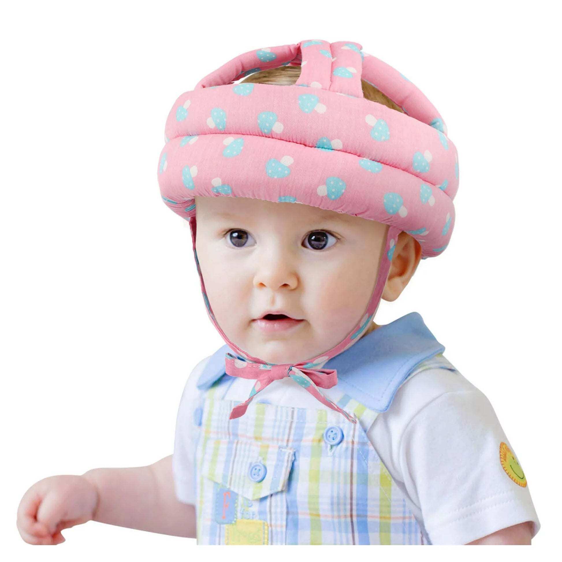 Baby wearing pink soft padded safety helmet for baby head protection while learning to walk