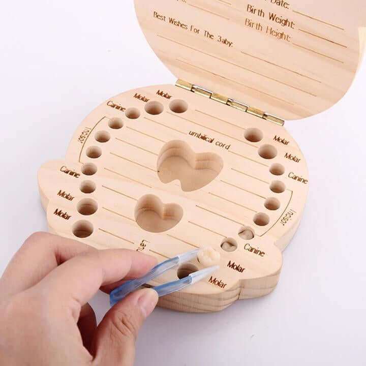 Baby wooden teeth organizer with engraved slots and heart-shaped design for keepsake storage.