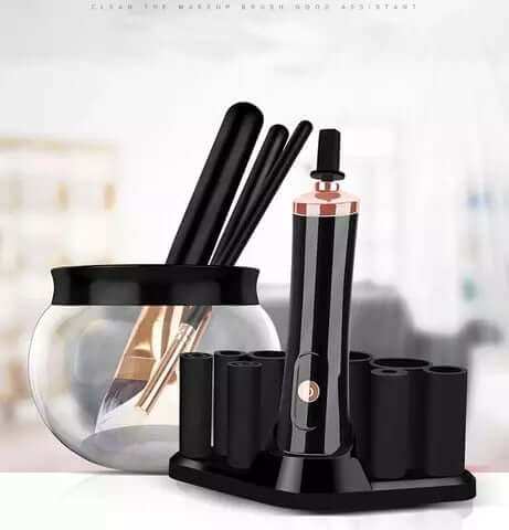 Electric makeup brush cleaning device with black handle, brush holder, and cleaning bowl.