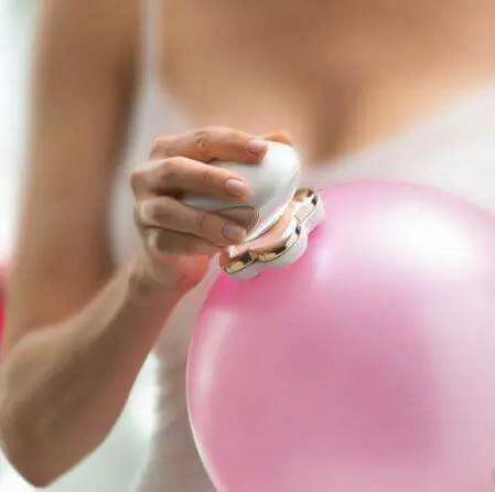 Women using Finishing Touch Flawless Legs hair remover on pink balloon.