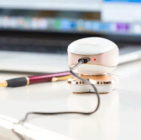 Portable Women Flawless Leg Hair Remover charging on desk with pen in background.